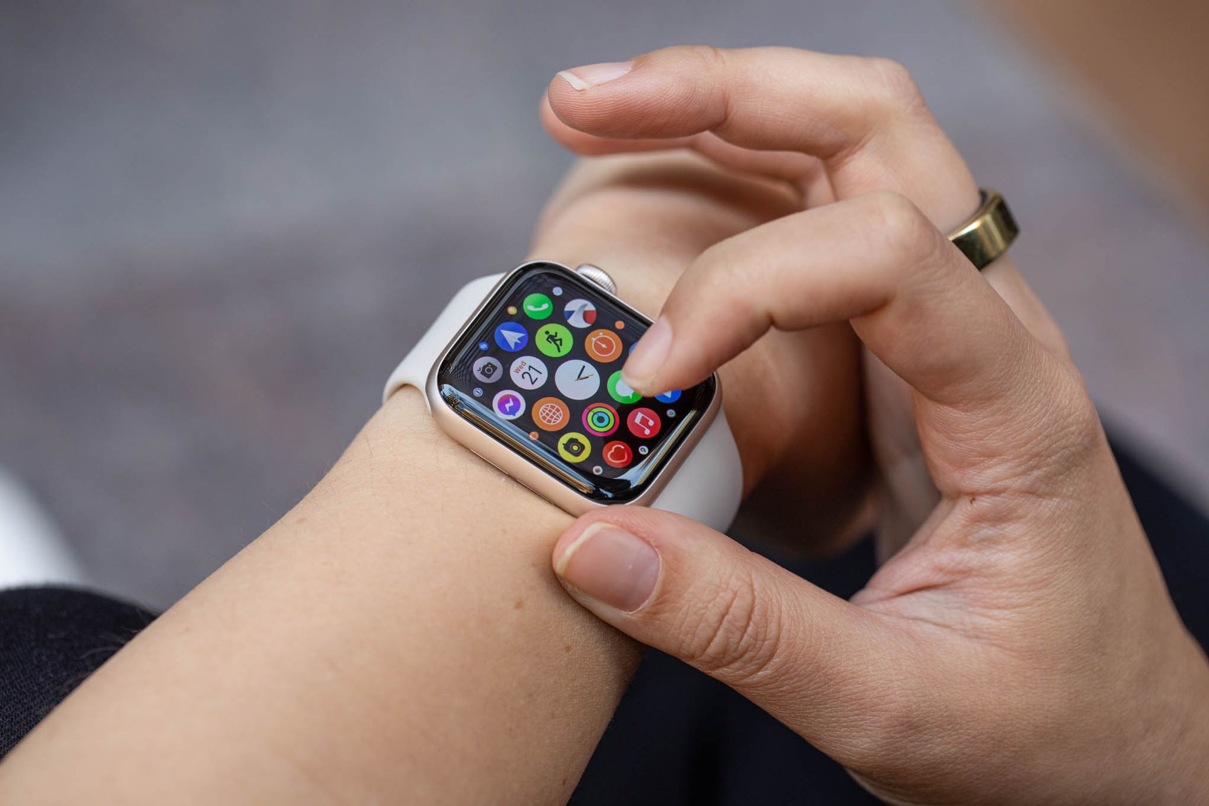 Woman looking at the app grid on the Apple Watch SE (2022).