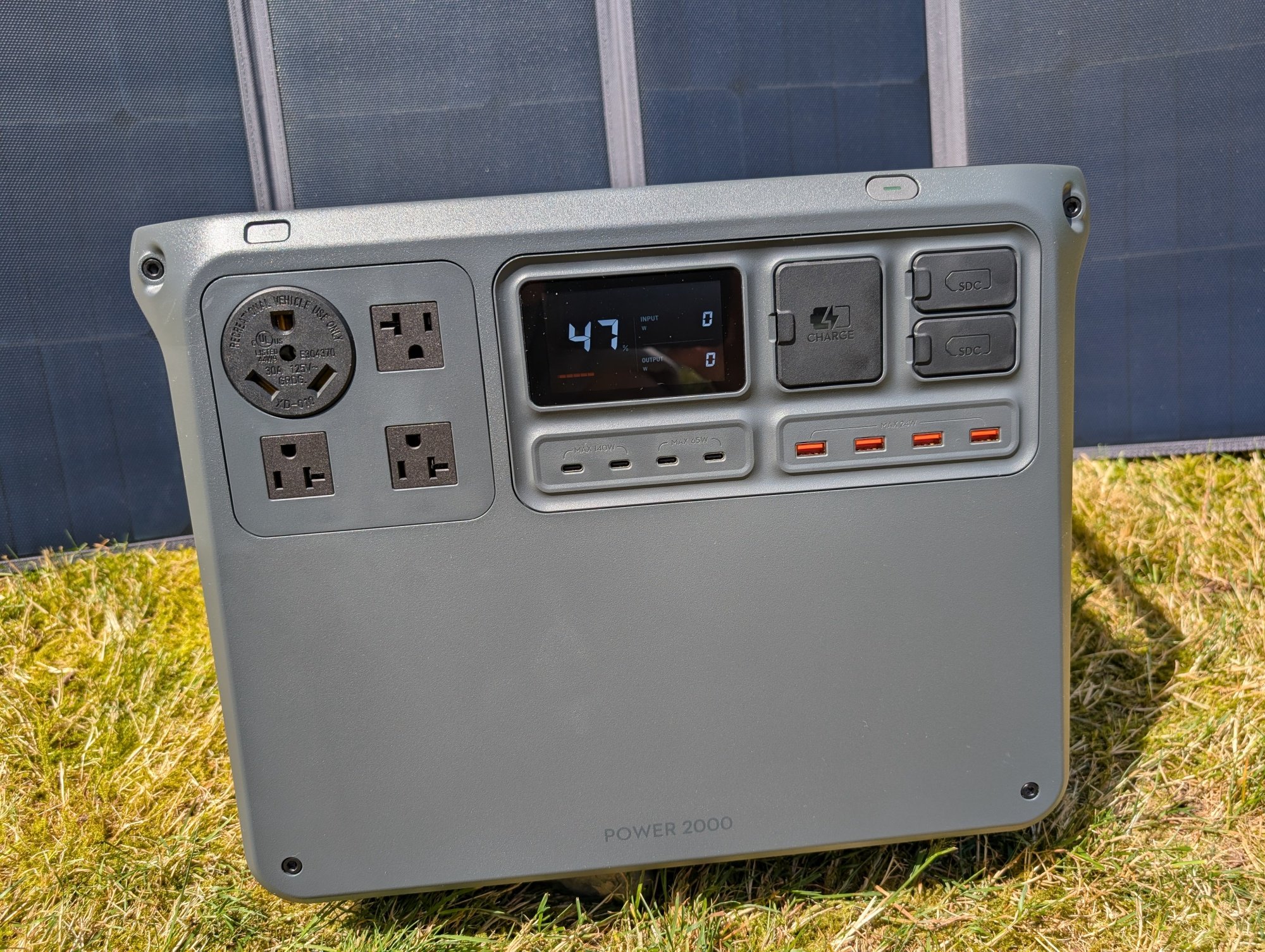the DJI power 2000 portable power station with solar panels behind