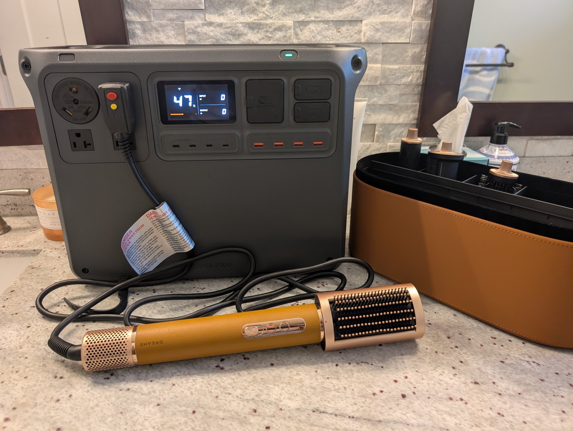 theDji power 2000 portable power station on a bathroom counter with a hair dryer plugged in