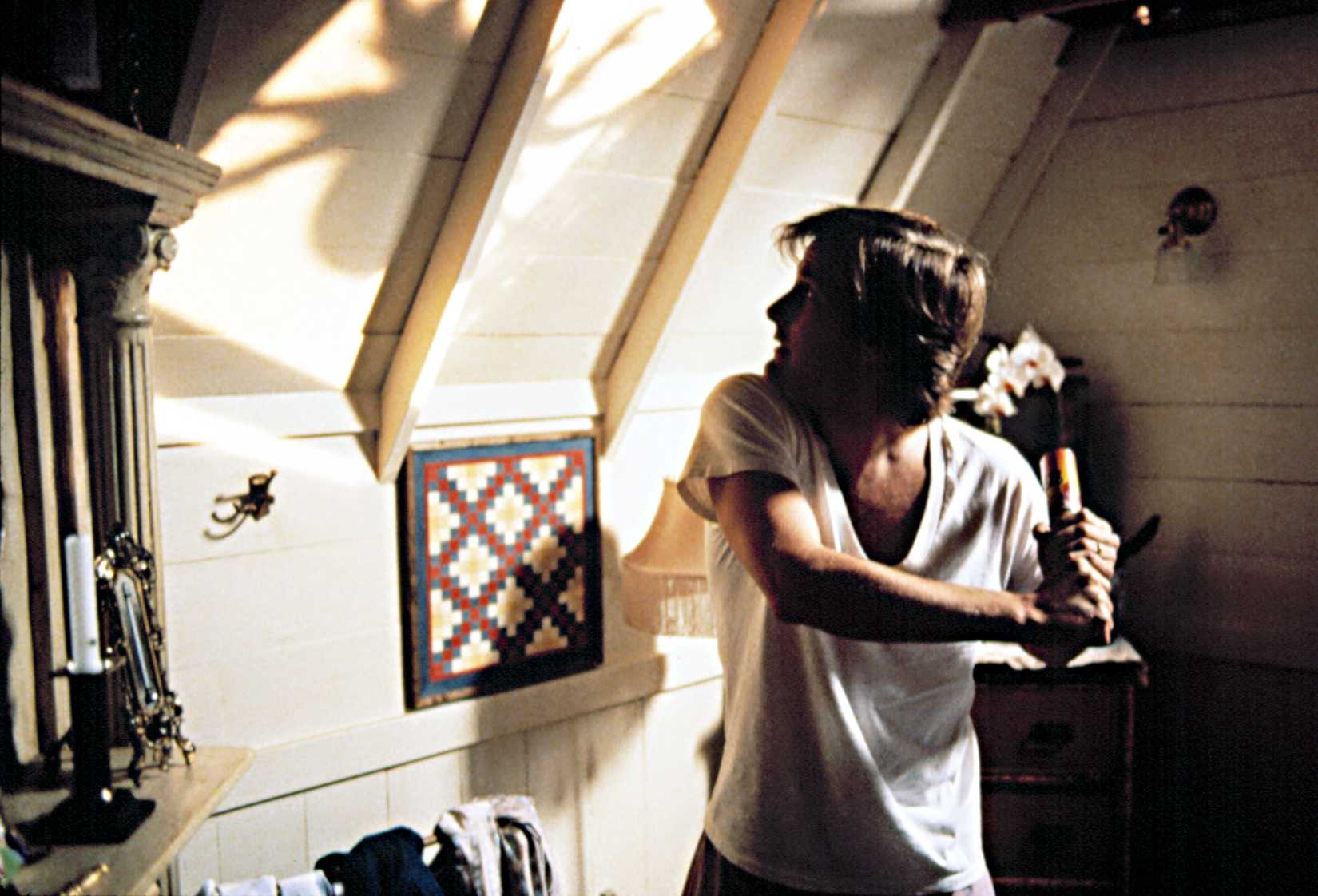 Jeff Daniels winds up to take an improvised weapon to a large spider on his wall in Arachnophobia