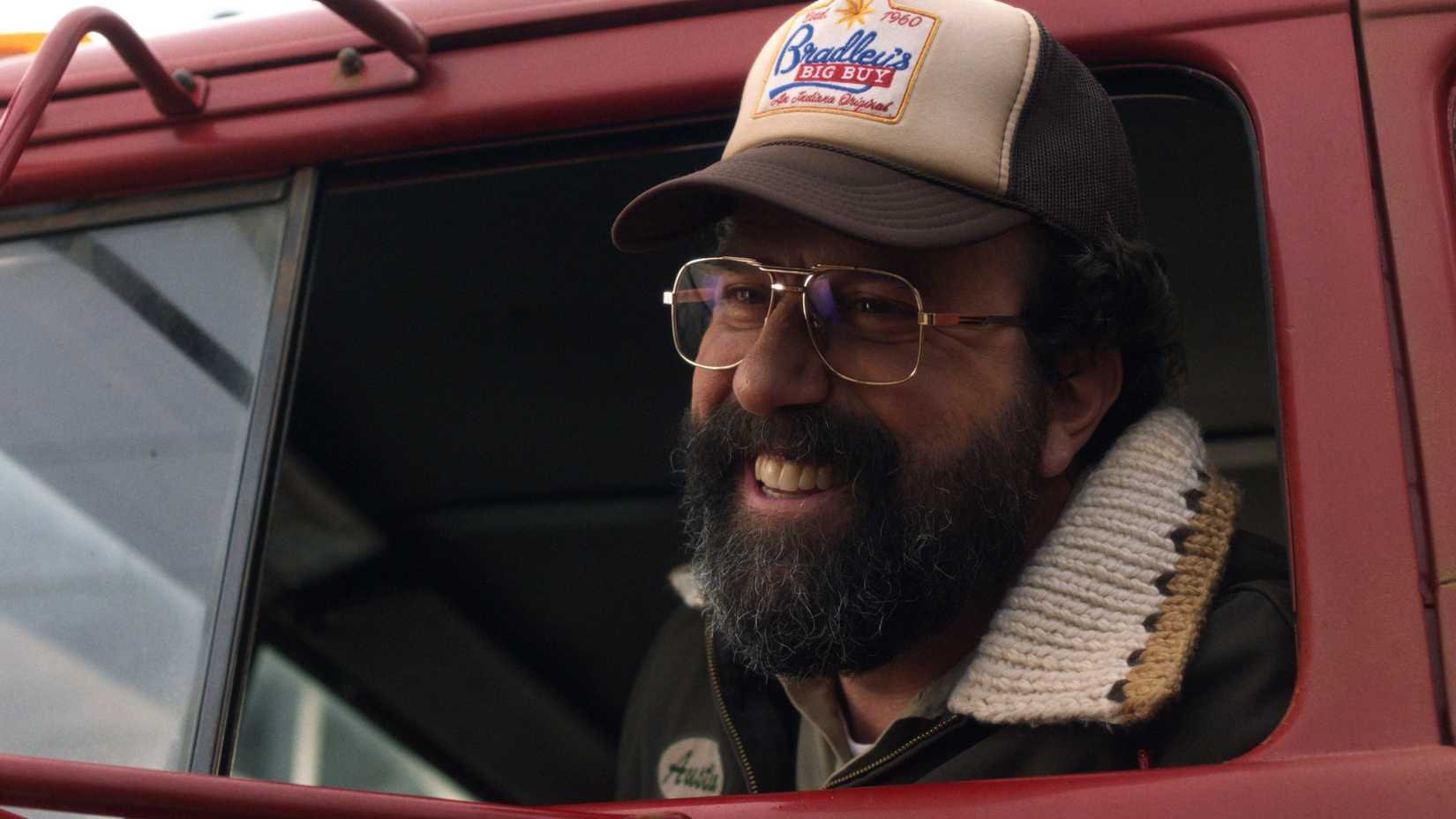 Brett Gelman as Murray Bauman looks out the window of his truck and smiles in Stranger Things season 5